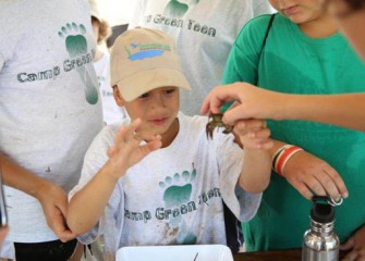 A staff volunteer explains the importance of crayfish to a healthy ecosystem