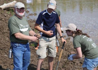 Joe McMullen, Principal Environmental Scientist, Terrestrial Environmental Specialists, finds a frog while planting.