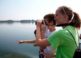 A Graduate Student from SUNY-ESF Shows Honeywell Summer Science Week Participant How to Use Binoculars to View Native Birds on Onondaga Lake.