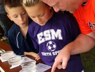 East Syracuse-Minoa Science Teacher John Herrington and His Two Children Examine Aquatic Bugs that Were Collected from Nine Mile Creek, Skaneateles Creek, and Carpenter's Brook.