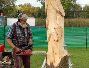 Chainsaw Artist Mike Wilson Carves a Trout at Honeywell Sportsmen's Days.