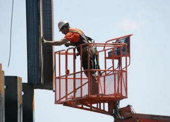 Worker Helps Guide Panel into Place