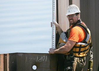 The Consistency and Height of Each Steel Panel is Checked as the Wall Expands