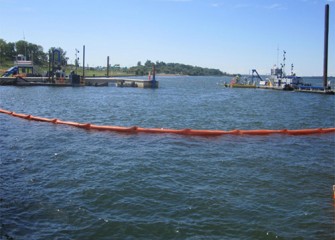 A silt curtain to help control water quality is deployed around a dredge area.