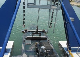 View from the dredge pilot house with cutter head lowered into the lake.