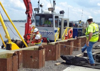 A support boat is ready to push off from the shoreline with captain at the wheel.