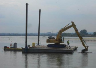 Smaller pieces of debris are removed by an excavator fitted with a rake