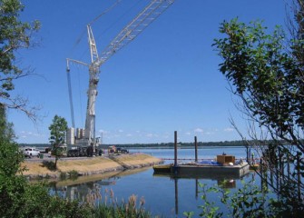 The crane is deployed near an area where debris will be removed before dredging