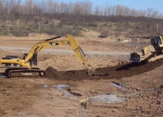 Workers place clean soil in the new wetlands