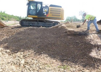 Worker mixes fungi and charcoal with compost