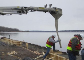 Concrete is poured behind the barrier wall.