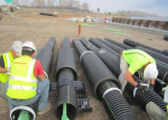 Workers prepare tension rods to support construction staging area.