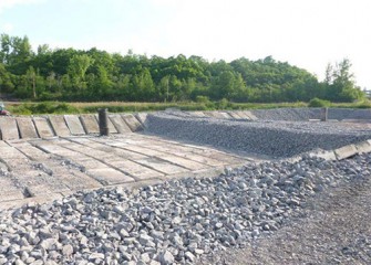 Concrete slabs are placed above the gravel to protect the liner.