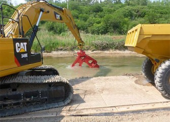 Excavators pick up the material and place it into waiting dump trucks.