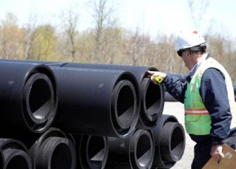 A worker examines sections of the double-walled pipe before delivery.