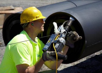 A Vari-Tech employee welds the double-walled pipe.