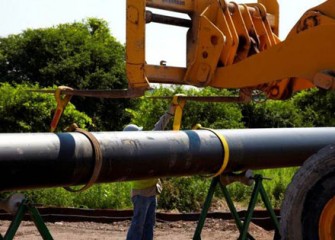 Sections of pipe are lowered into place as construction of the pipeline begins.