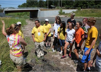 Honeywell Summer Science Week at the MOST students listen as team leader explains the water sampling process at Onondaga Creek