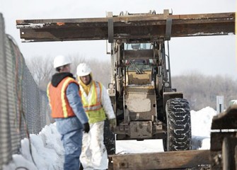 Workers Move Steel Panel
