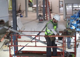 Worker installing lighting conduit