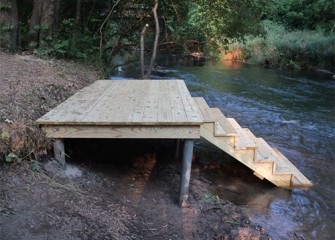 A dock is installed upstream along a trail.