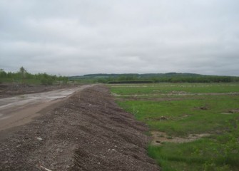 Preparation to build the consolidation area begins with roads and containment berms.