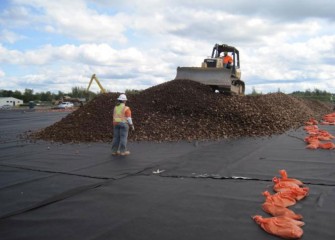 Spotters Assist with Placement of the Drainage Gravel Over the Liner