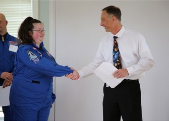 Math Teacher Mary Newman of Hughes Pre-K – 8 School (Syracuse) is welcomed to Honeywell Educators @ Space Academy.