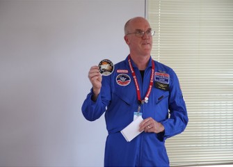 Honeywell Educators @ Space Academy 2012 alumnus Dan Howard, Technology Teacher at West Genesee Middle School, displays his Apollo 13 patch while discussing lessons learned at Space Camp.