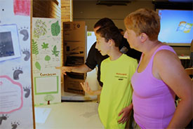 Families, teachers, and students gather to look at presentations of the students' observations made during Honeywell Summer Science Week at the MOST.