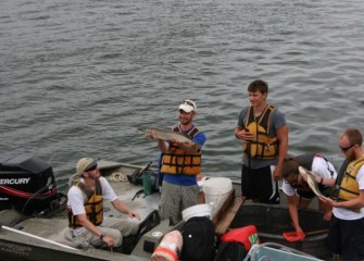 SUNY-ESF research assistants show students samples of fish living in Onondaga Lake.