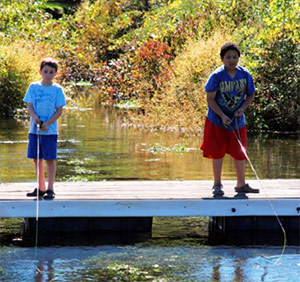 Eamon Willoughby (left), of Jordan, N.Y., and Stephen Malcoln (right), of Syracuse, N.Y., learn how to fly fish during the 2013 Honeywell Sportsmen's Days at Carpenter's Brook.