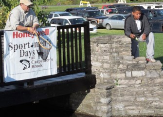 Jim Fitzgerald (left), of Kirkville, watches Aaron Butler, of Auburn, as he learns how to fly fish in Carpenter’s Brook.