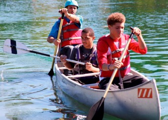 Marcus Landers (front), Donavan Lynn (center), and Quentin Lynn of Syracuse paddle across the pond.