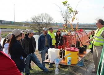 Ray D’Hollander, Parsons environmental engineer and Corps volunteer, shows participants native trees they will help plant.