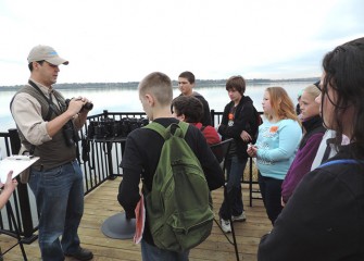 Onondaga Audubon Society Board Member Frank Moses shows students how to use binoculars.