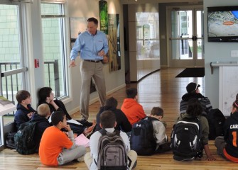 Honeywell Syracuse Program Director John McAuliffe answers students’ questions about lake restoration activities after they view a video about the lake cleanup process.