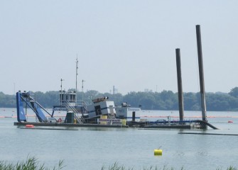 Lake material is suctioned into a pipeline, lower right, and transported to the consolidation area.