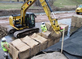 Workers create gabions, wire baskets filled with rocks and topsoil, to provide stability along the steep Nine Mile Creek shoreline.