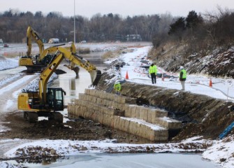 Work on a retaining wall continues in winter, taking advantage of the low flow period in the creek. Later when shrubs and trees are added, the wall will take on the appearance of a natural shoreline.