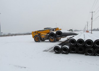 New sections of double-walled pipe, manufactured locally, are stockpiled before welding.