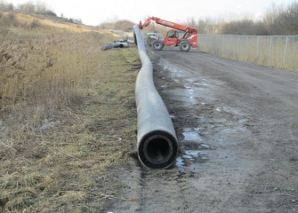 A new section of pipeline is moved into place. The pipeline will be tested with water before lake material is transported through it.