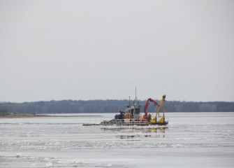 A support boat moves out into the ice-covered lake in preparation for the start of lake activities.