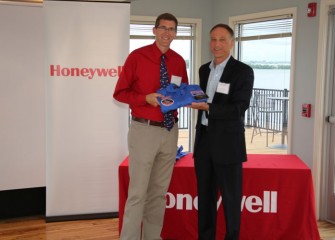 Math teacher Christopher Ludden, C.W. Baker High School in Baldwinsville, receives his flight suit from Honeywell Syracuse Program Director John McAuliffe.