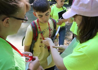 West Genesee Middle School student Katherine Baldwin (right) examines an insect on her forearm.  Listening are Jeffrey Bush (center) from Camillus Middle School and Counselor Renee Halloran, a SUNY-ESF student.