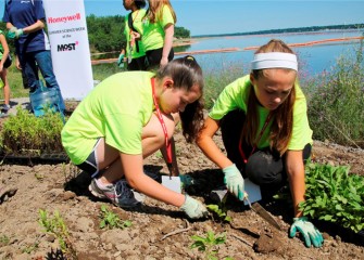 Abigail Zumbuhl (left), from Jamesville-DeWitt Middle School, plants black-eyed Susan together with Anna Markert, from Pine Grove Middle School in East Syracuse.