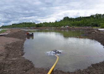 A week after the Corps event, rain and pumped water begin to fill the new wetland along Onondaga Lake’s western shoreline.  The area planted by Corps volunteers is in the background.