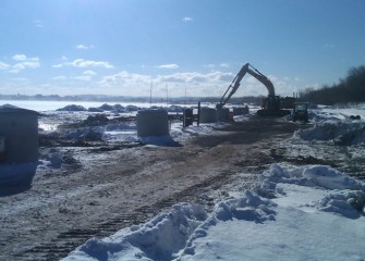 Tall concrete well casings protect the groundwater collection system during construction activities.