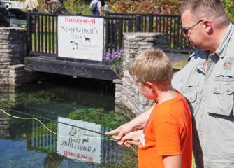 A Trout Unlimited volunteer assists Ty Corey from Phoenix, NY, with fly fishing in Carpenter’s Brook.