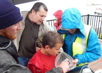 David Emerson (center foreground) came with his family from Oxford, NY, to participate in the BioBlitz.  Here David learns about the characteristics of a tadpole madtom (a type of small fish) netted in the lake.